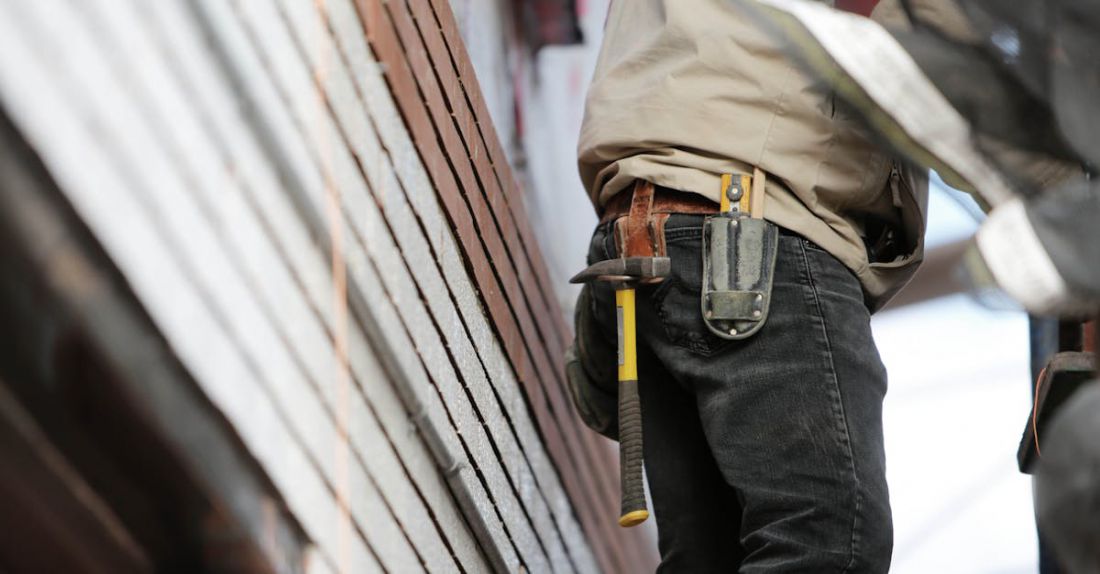 Builders - Man Wearing Black Denim Pants With Carrying Hammer on Holster